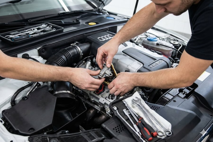 Two men working on a car engine.